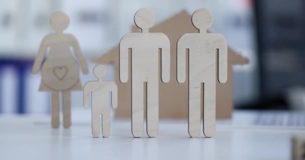 Figuras de madera de pareja casada masculina con niño en segundo plano mujer embarazada con casa. Matrimonio por concepto de parejas del mismo sexo - Imágenes, Vídeo
