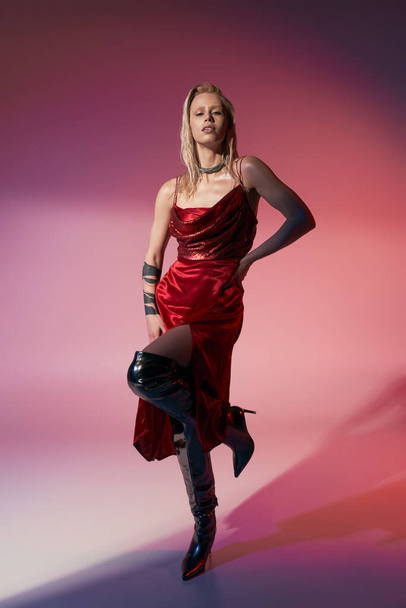 giovane attraente modello femminile con accessori in abito rosso elegante in posa su sfondo rosa - Foto, immagini