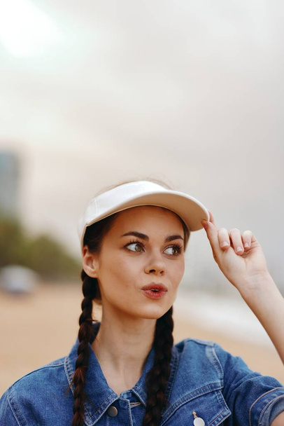 Neşeli genç bayan, yaz tatilinin tadını çıkarıyor, Yeşil Park 'ta şık bir şapkayla duruyor. - Fotoğraf, Görsel