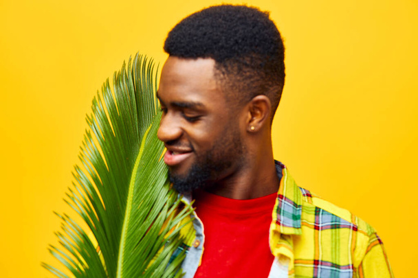 男 スタイル 笑顔 陽気な大人のファッション アフロートトロピカル人 幸せなフリーランサー レジャー パームツリー 黒 黄色 楽しい アフリカの表現 スタイリッシュな色 アメリカ - 写真・画像