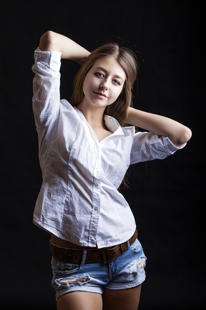 Portrait young girl in a blue jeans jacket and shorts in dark st - Foto, Bild