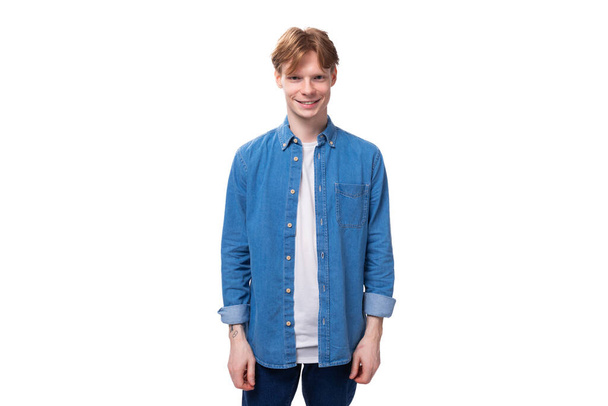 young successful cute caucasian guy with short red hair is dressed in a white t-shirt with a blue shirt. - Photo, Image
