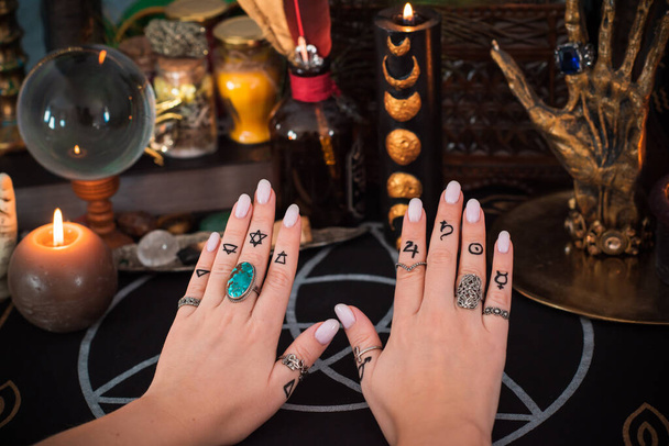 Gyűrűk az ujjadon. A gyűrű ezoterikus és asztrológiai szimbóluma. Jelenet női kézzel - Fotó, kép
