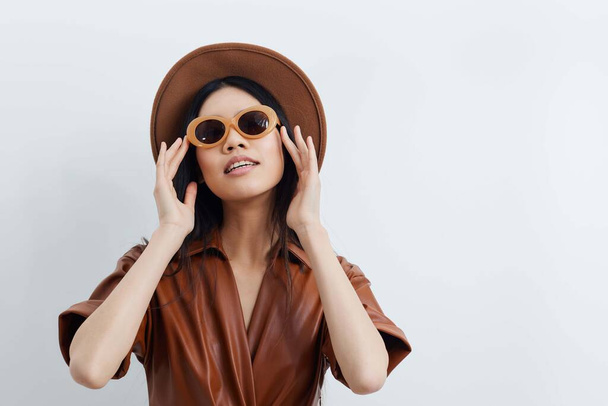 Μοντέλο γυναίκα ομορφιά χαριτωμένο μόδα ελκυστικό σαλόνι ασιατικό μπεζ πρόσωπο lifestyle θηλυκότητα καπέλο αίγλη ταξίδια καλλυντικά διακοπές όμορφα μαλλιά γυαλιά ηλίου πορτρέτο - Φωτογραφία, εικόνα