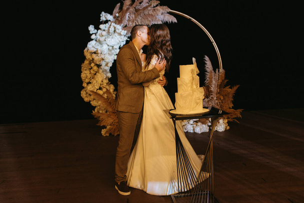 newlyweds happily cut, laugh and taste the wedding cake - Fotografie, Obrázek