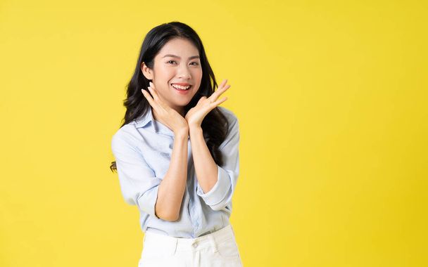 Porträt der schönen asiatischen Mädchen posiert auf gelbem Hintergrund - Foto, Bild