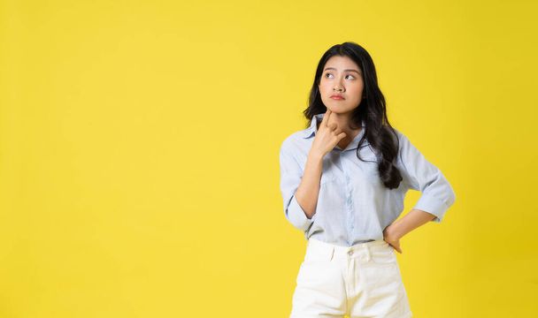 retrato de hermosa chica asiática posando sobre fondo amarillo - Foto, imagen