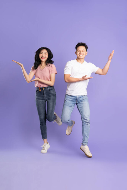 Ganzkörperbild von asiatischen Paar posiert auf lila Hintergrund - Foto, Bild