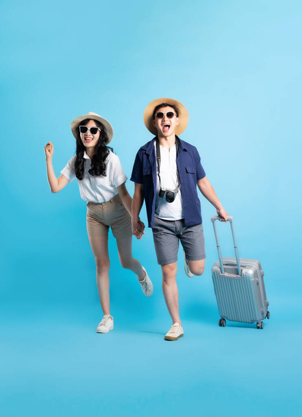 Asiatisches Paar auf Reisen Bild isoliert auf blauem Hintergrund - Foto, Bild