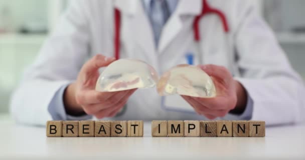 Tahta küplerden yapılmış göğüs implantı silikon silikon takan kadın doktorlara karşı. Kadın cerrah yavaş çekimde implantların yumuşaklığını gösteriyor. - Video, Çekim