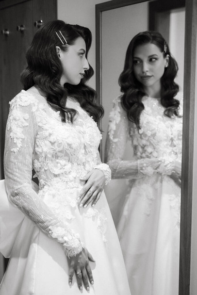 brązowłosy dziewczyna stawia na suknię ślubną w pokoju hotelowym rano - Zdjęcie, obraz