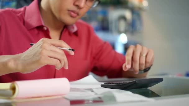 Chinois homme avec calculatrice vérification des factures dans la boutique d'ordinateur
 - Séquence, vidéo