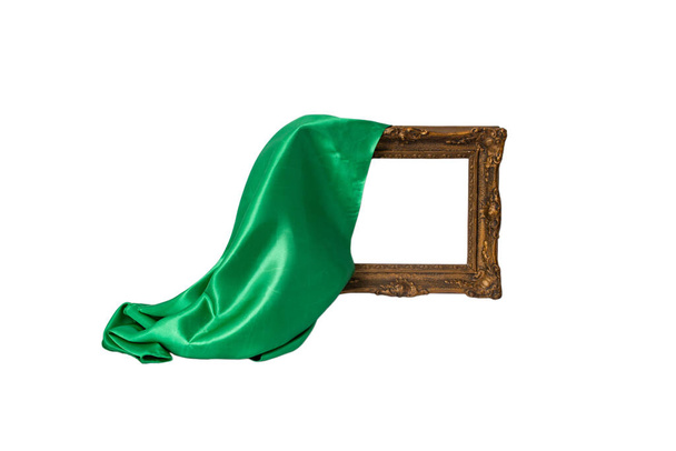 Tessuto di raso verde che svela una cornice di legno vintage vuota, isolata su sfondo bianco,  - Foto, immagini