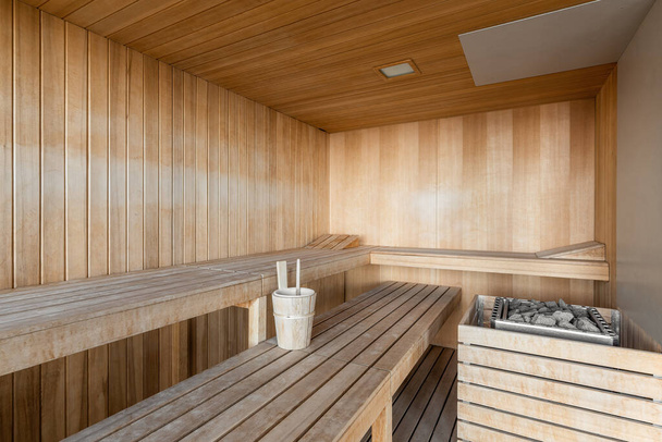 Κλασικό ξύλινο εσωτερικό της φινλανδικής σάουνας με παγκάκια και ξαπλώστρες αξεσουάρ για ζεστές διαδικασίες - Φωτογραφία, εικόνα