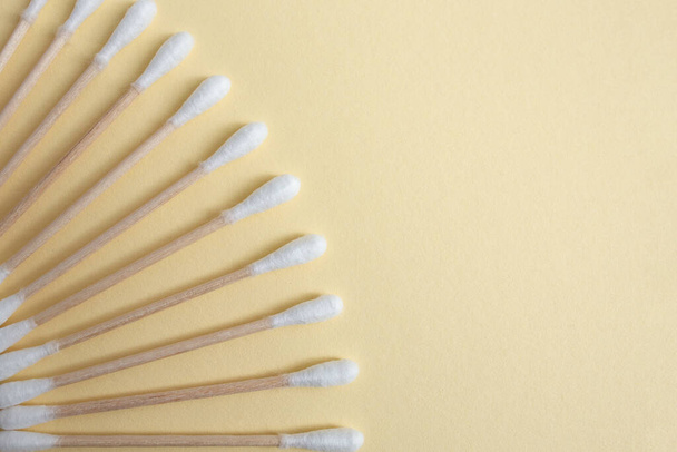 Wooden sticks cotton buds arranged like a fan on beige background  - Photo, Image