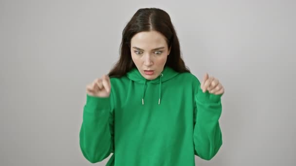 Erstaunliche junge Frau im Sweatshirt, mit schockiertem Gesichtsausdruck, die überrascht auf eine großartige Anzeige auf weißem, isoliertem Hintergrund zeigt. - Filmmaterial, Video