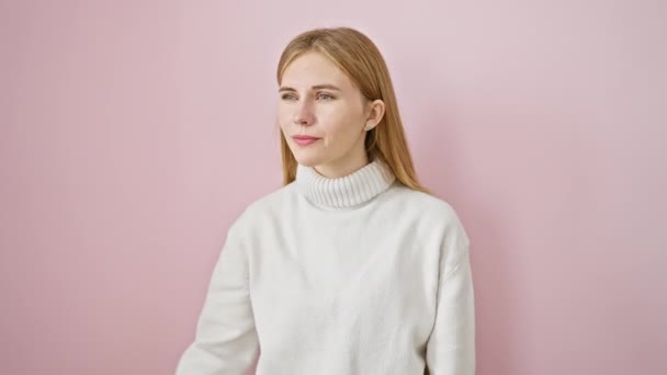 Happy, attractive blonde girl confidently posing, hand over eyes searching far away. isolated pink background framing her winter smile. - Footage, Video