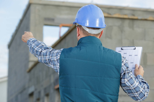 a worker pointing at clipboard - Foto, immagini