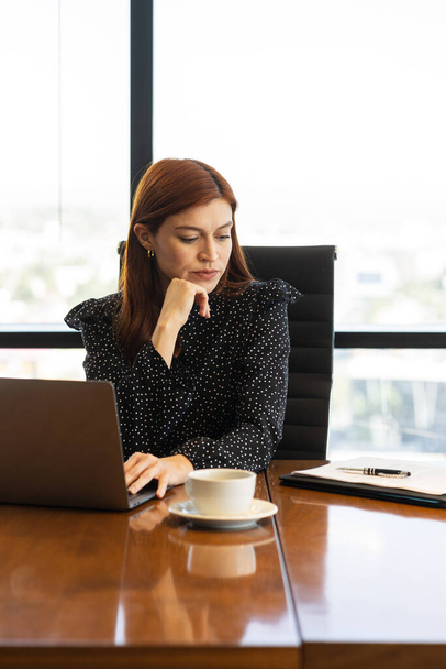 Retrato de uma mulher de negócios bonita examinando um contrato e usando um computador em uma sala de reuniões - Foto, Imagem