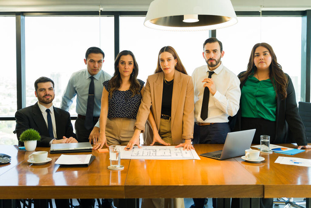 Grupo inclusivo y diverso de personas que trabajan juntas en una sala de reuniones y hacen contacto visual - Foto, Imagen