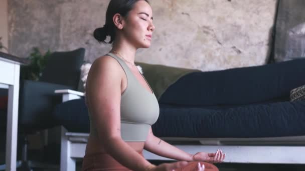 Mediteren, mindfulness en Aziatisch, vrouw en lotus poseren voor zen thuis met yoga, wellness voor spiritueel en holistisch welzijn. Gezondheid, rust en meditatie in de woonkamer, rust en balans voor aura. - Video