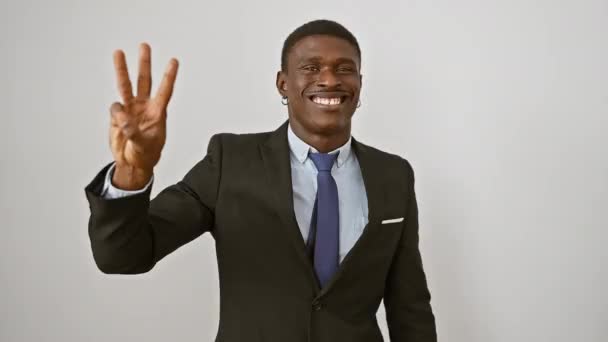 Veselý afroameričan v obleku radostně zvedá tři prsty a signalizuje třetí myšlenku. izolované na bílém pozadí, stojící, usmívající se, komunikace živá - Záběry, video