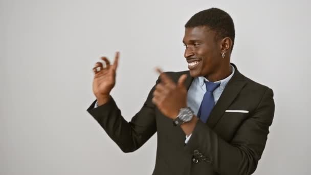 Afroamerikanerin im Anzug steht lächelnd in die Kamera und zeigt mit beiden Händen und Fingern zur Seite. über isoliertem weißem Hintergrund - Filmmaterial, Video