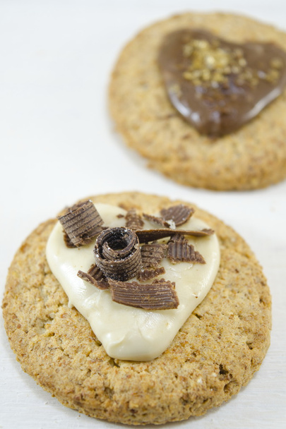 Biscotti di farina d'avena con crema e cioccolato su bianco
 - Foto, immagini