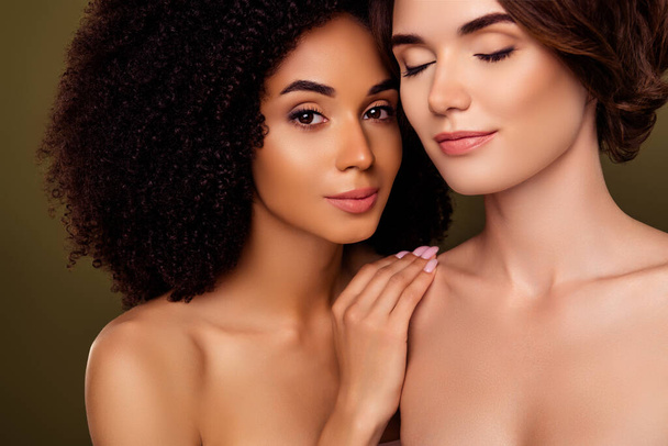 Ritratto estetico di due donne attraenti dopo la procedura di pulizia della pelle del viso spa isolato su sfondo di colore kaki. - Foto, immagini
