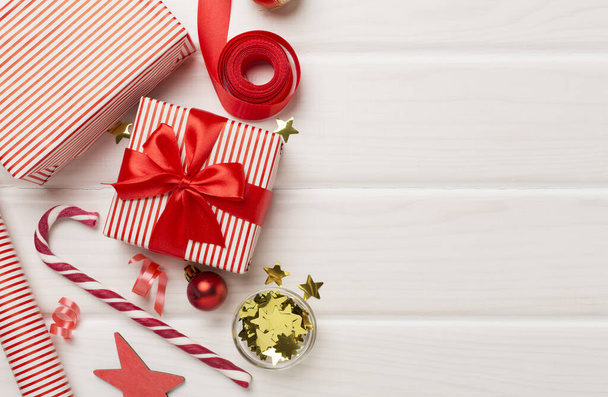 Dárkové krabice s papírovými roletami a vánoční ozdobou na dřevěném pozadí, pohled shora - Fotografie, Obrázek