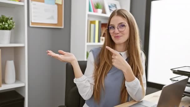 Joyful young blonde business woman gesturing the okay sign with her palm, flashing a radiant smile and a thumbs up, exuding confidence in the indoor office setting. - Footage, Video