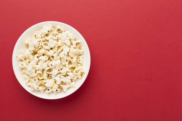 Ízletes popcorn tálban színes háttér - Fotó, kép