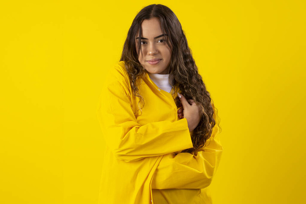 young woman, a yellow raincoat on a yellow background - Photo, Image