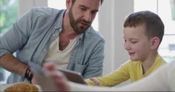 Home, kind en vader leren met een tablet samen met onderwijs, app en games online. E-learning, technologie en papa helpen kinderen in de woonkamer met leesboek of website voor huiswerk op school. - Video