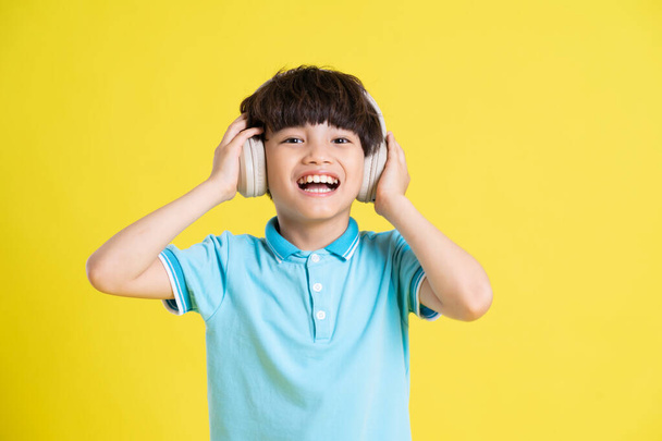 portrait of an asian boy posing on a yellow background - Foto, Imagem