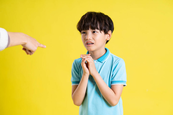 portrait d'un garçon asiatique posant sur un fond jaune - Photo, image