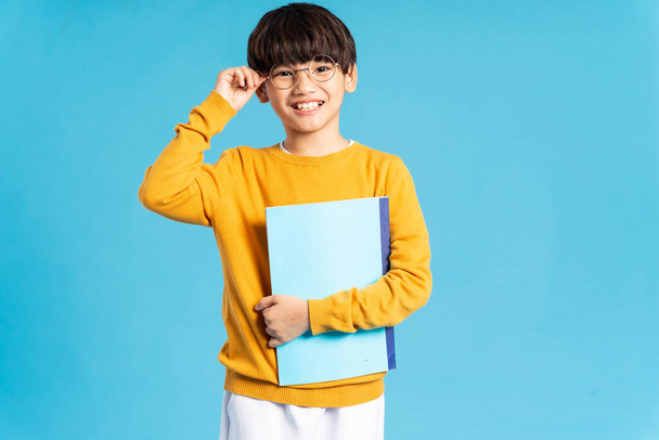 Portrét asijského školáka narozeného na modrém pozadí - Fotografie, Obrázek