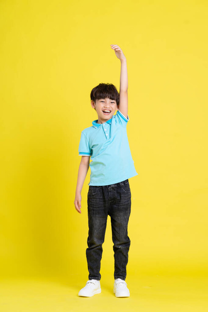 corpo inteiro imagem de asiático menino posando no amarelo fundo - Foto, Imagem