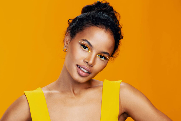 Kozmetikai nő kozmetika mosoly szépség modell kreatív fekete színes arc stúdió portré stílus afrikai smink bőr divat sárga gyönyörű - Fotó, kép