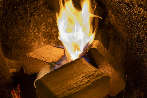 Briquetas de madera (tipo ruf), hechas de haya y roble quemándose dentro de la caldera de combustible de madera. Combustible alternativo, combustible ecológico, biocombustible. - Foto, imagen