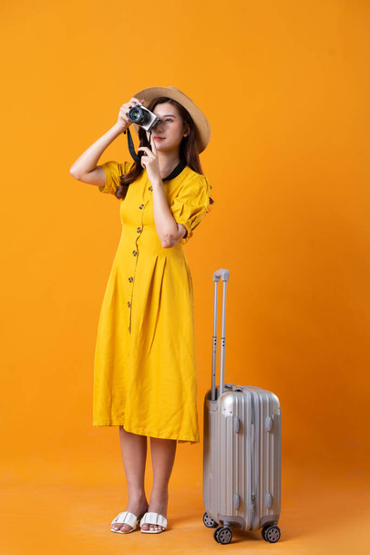 portrait de belle fille asiatique portant robe jaune sur fond orange - Photo, image