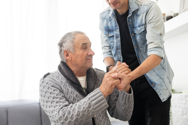 Elderly son takes care of ill father . High quality photo - Photo, Image