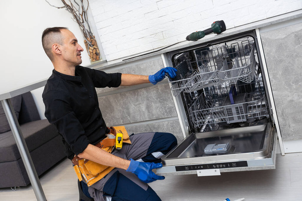 Servicio de reparación de electrodomésticos para lavavajillas. Reparador de Mantenimiento del Hogar. Foto de alta calidad - Foto, imagen