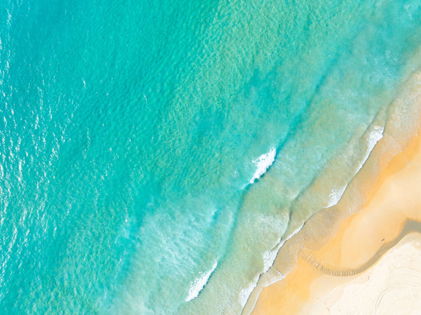 Plage vue de dessus avec vagues s'écrasant sur le rivage sablonneux, Belles vagues surface de la mer en arrière-plan de paysage marin d'été, Incroyable plage fond d'eau coloré - Photo, image