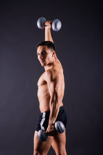 Portrait young fitness sporty strong man barechested muscular sportsman isolated on grey dark. - Photo, Image