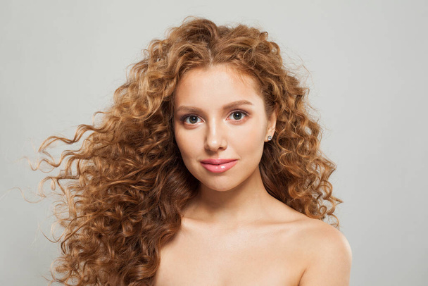 Modelo de moda mulher ruiva bonito com cabelo marrom encaracolado brilhante e pele fresca saudável natural no fundo branco. Cosmetologia, cabeleireiro e conceito de tratamento de beleza - Foto, Imagem
