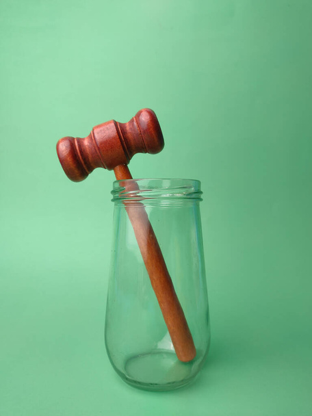 Gavel en bois sur bocal en verre sur fond vert avec espace de copie. - Photo, image
