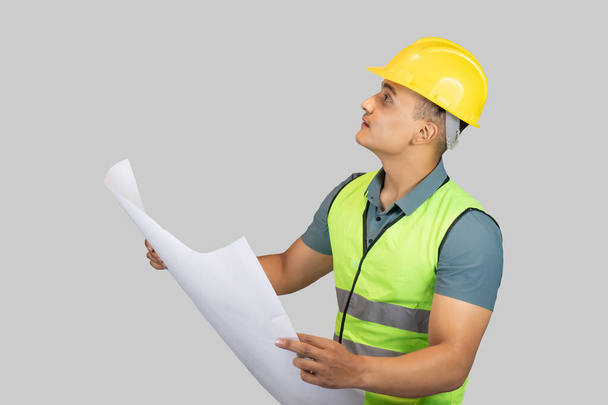 An Asian Happy Construction Worker Engineer giving expression gestures with chartpaper and notebook - Foto, afbeelding