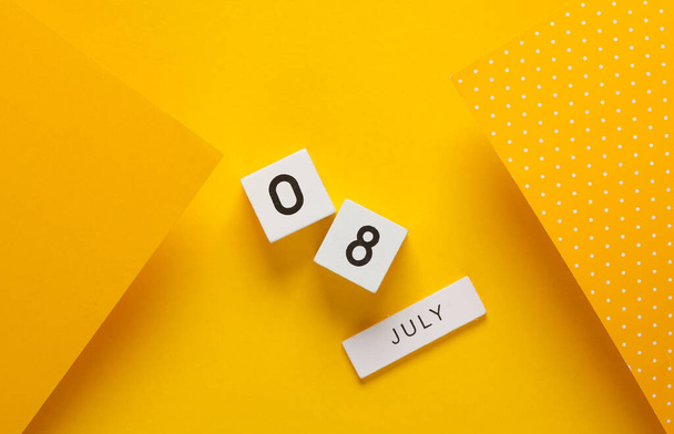 Белый календарь с датой 8 июля на желтом фоне. Креативная планировка - Фото, изображение