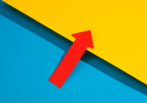 Freccia rossa che punta su uno sfondo giallo-blu - Foto, immagini